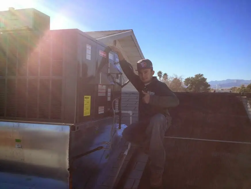 HVAC technician performing Heat Pump Repair on a rooftop unit in Craig