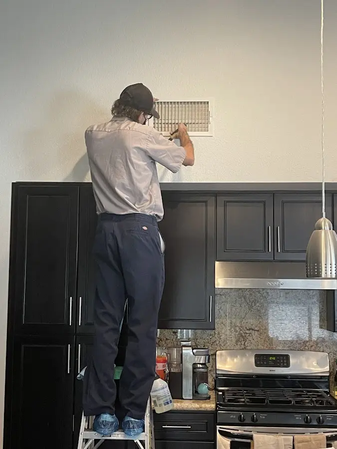 Technician inspecting an air vent during HVAC service in Craig